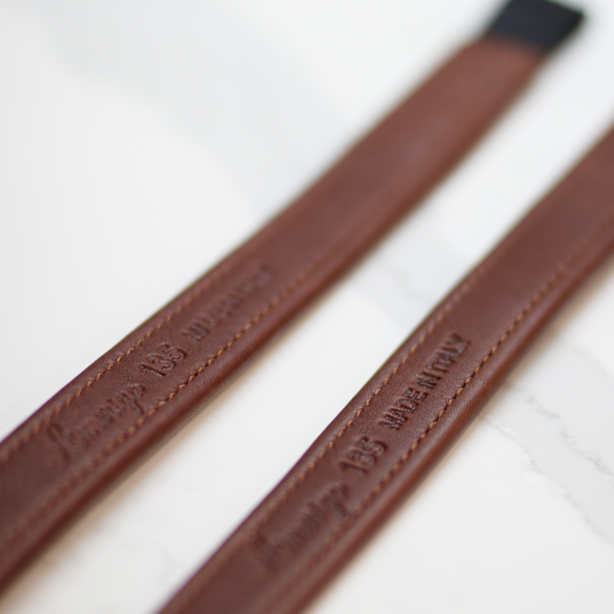 Close-up of brown Amerigo mono stirrup leathers with stamped Amerigo logo on the mid-section