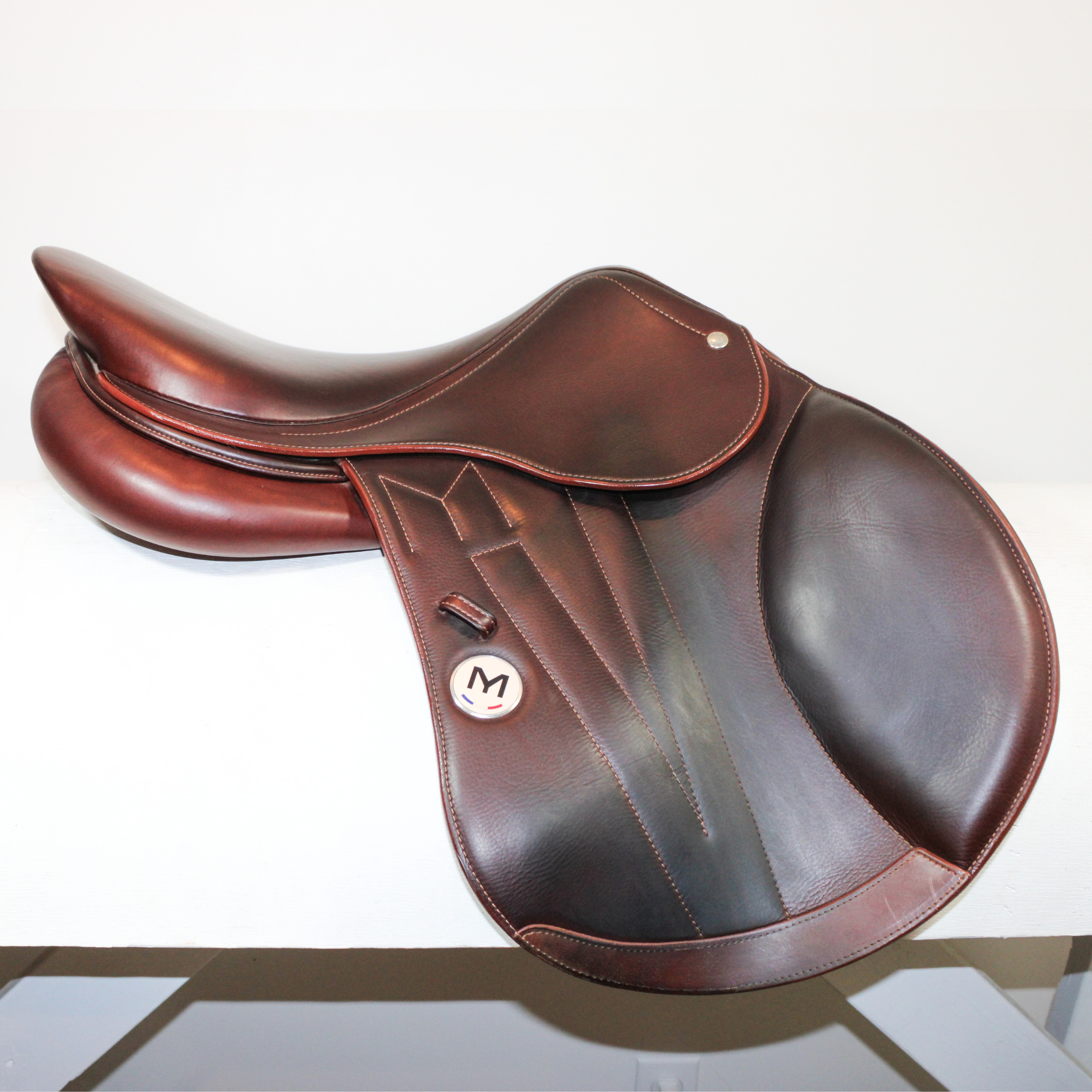 Right side profile view of a Meyer Act 2 jump saddle in brown calf leather with a white Meyer logo, decorative stitching on flap, and lower flap reinforcement.