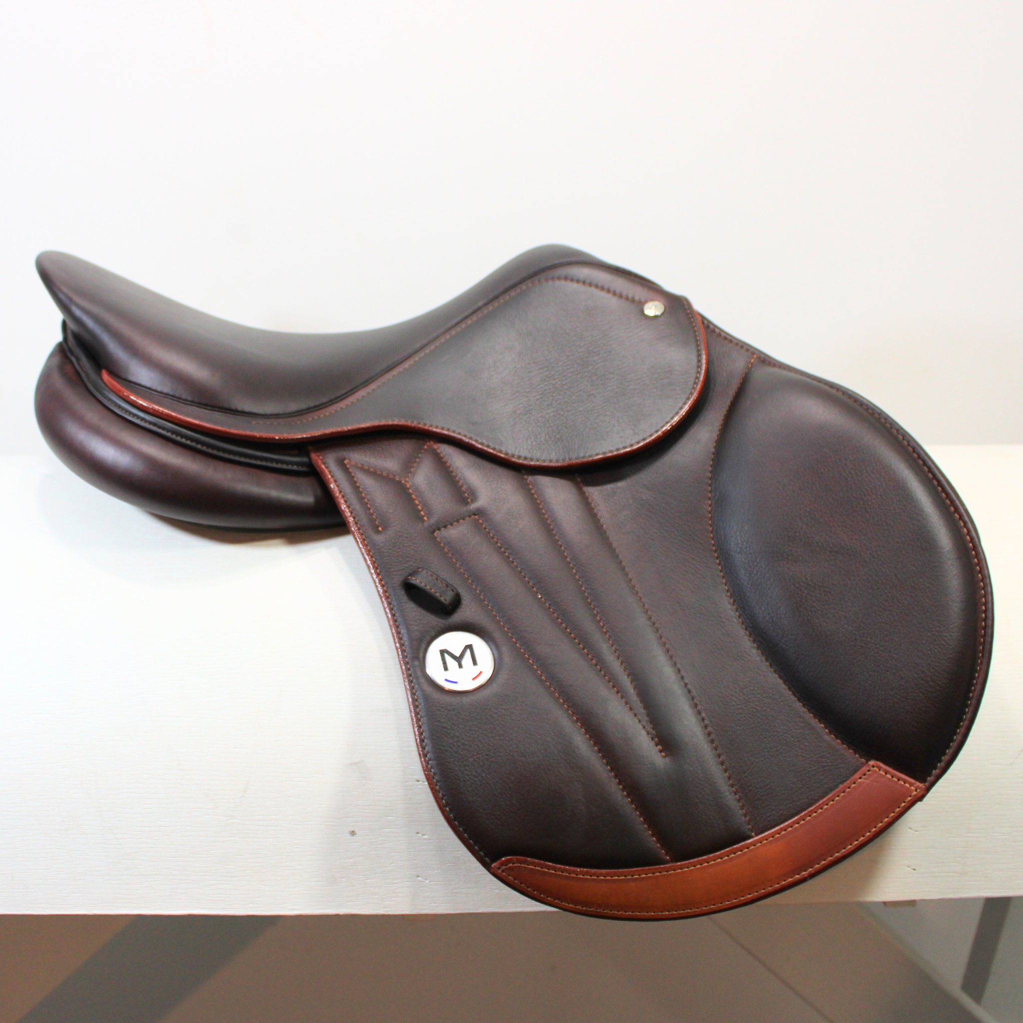 Right side profile view of a Meyer Act 1 jump saddle in brown calf leather, with a white Meyer logo, decorative stitching on flap, and lower flap reinforcement.