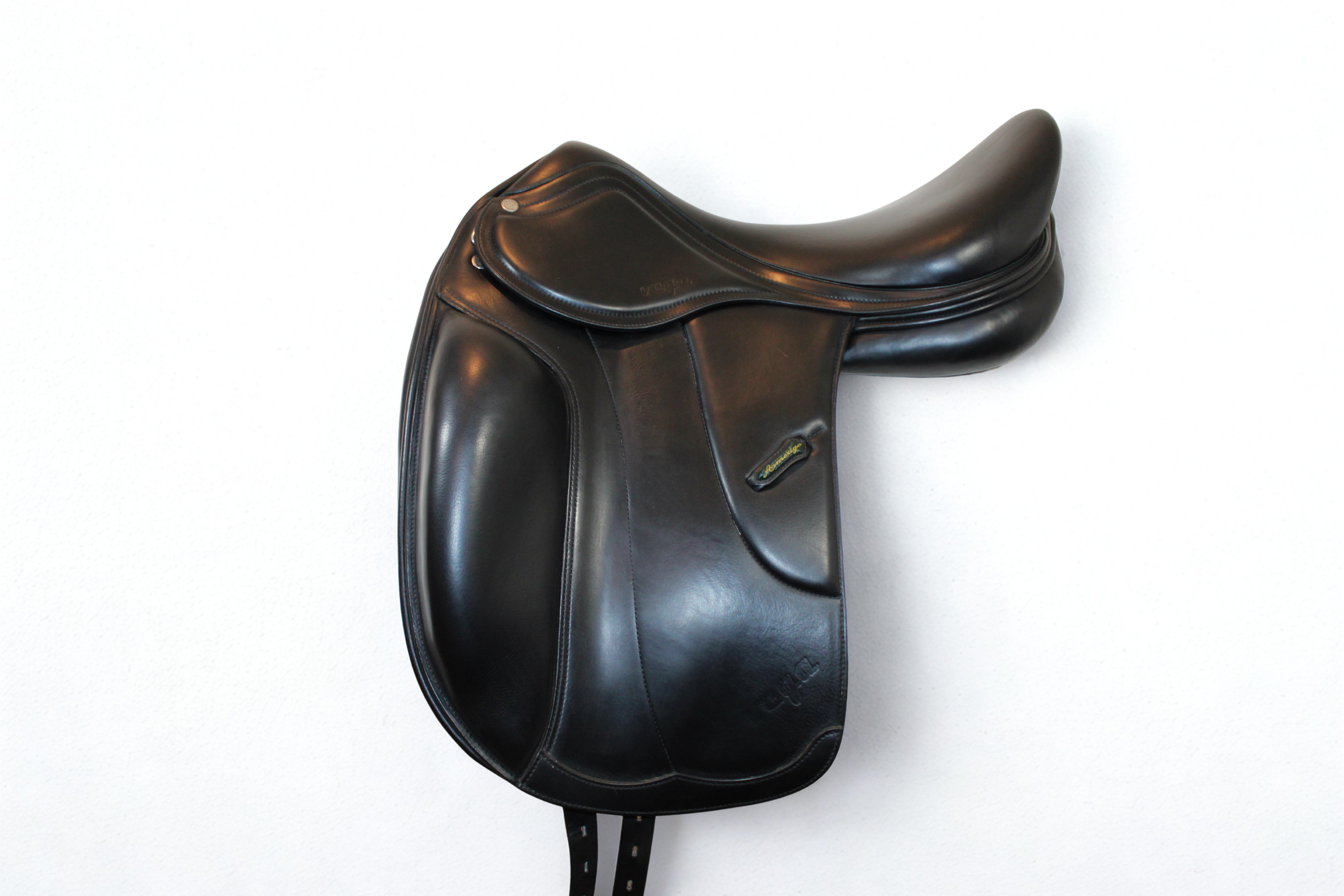 Left side profile view of an Amerigo Vega dressage saddle in black calf leather, with a green and yellow Amerigo logo loop.