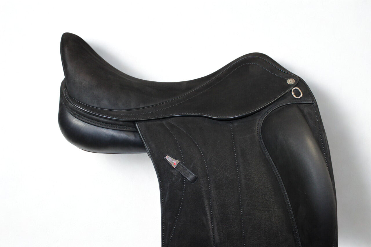 Close up right side profile view of an Equipe Victoria dressage saddle in black buffalo leather, with a silver emblem on the stirrup leather keeper.