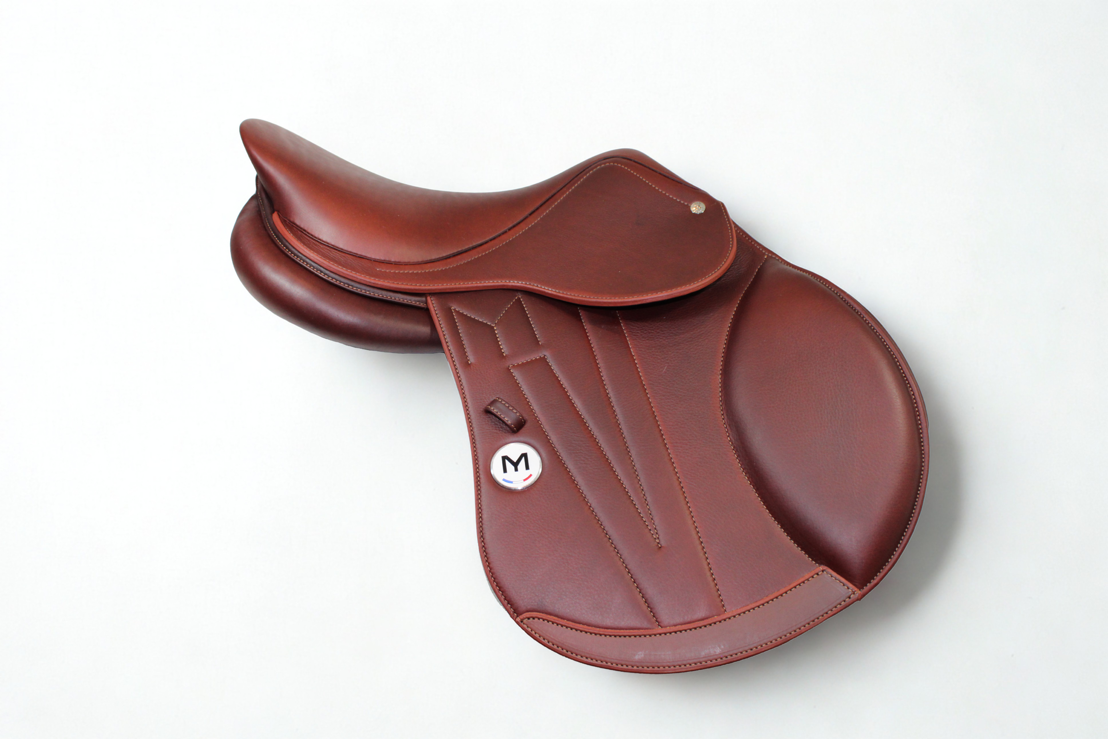 Right side profile view of a Meyer Act 1 jump saddle in brown calf leather, with a white Meyer logo, decorative stitching, and lower flap reinforcement.