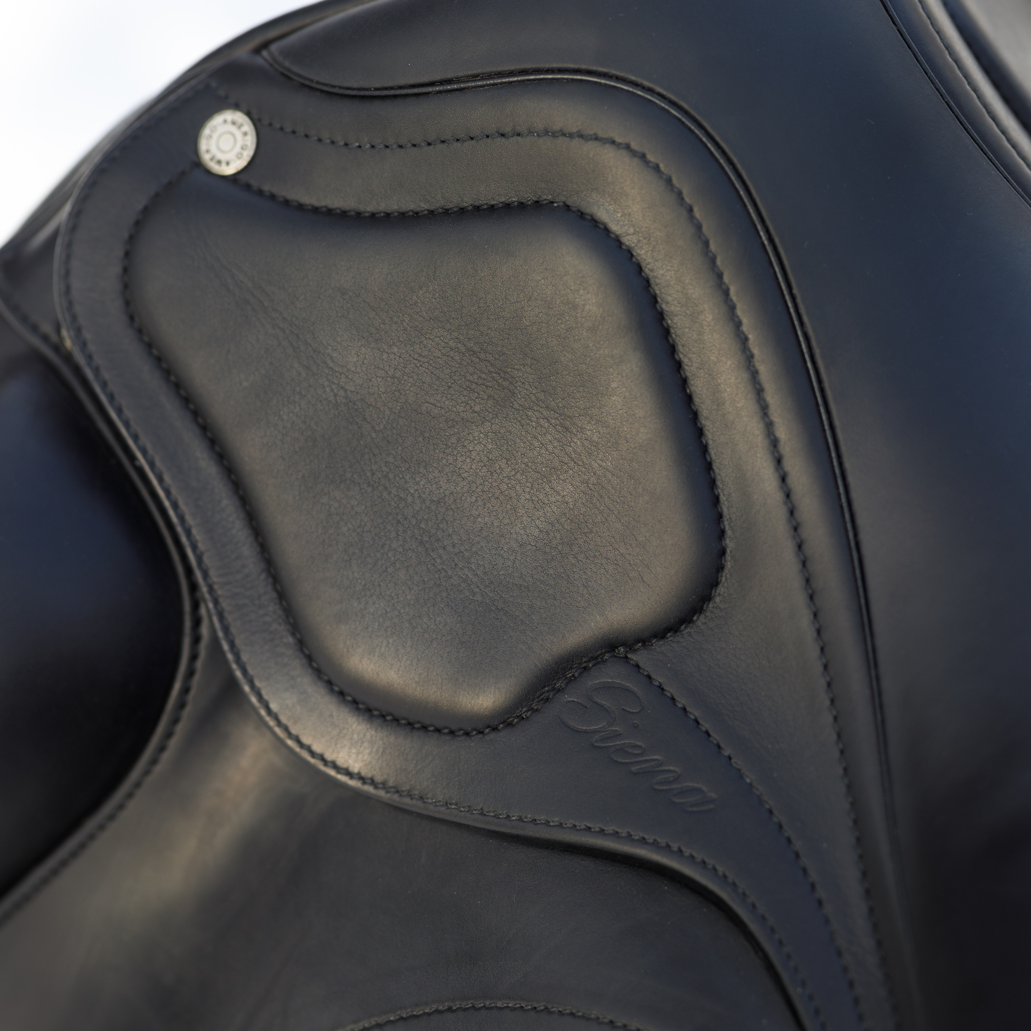 Close up photo showing the padded skirt of a black Amerigo Classic dressage saddle. The saddle is stamped with 'Siena' on the skirt.