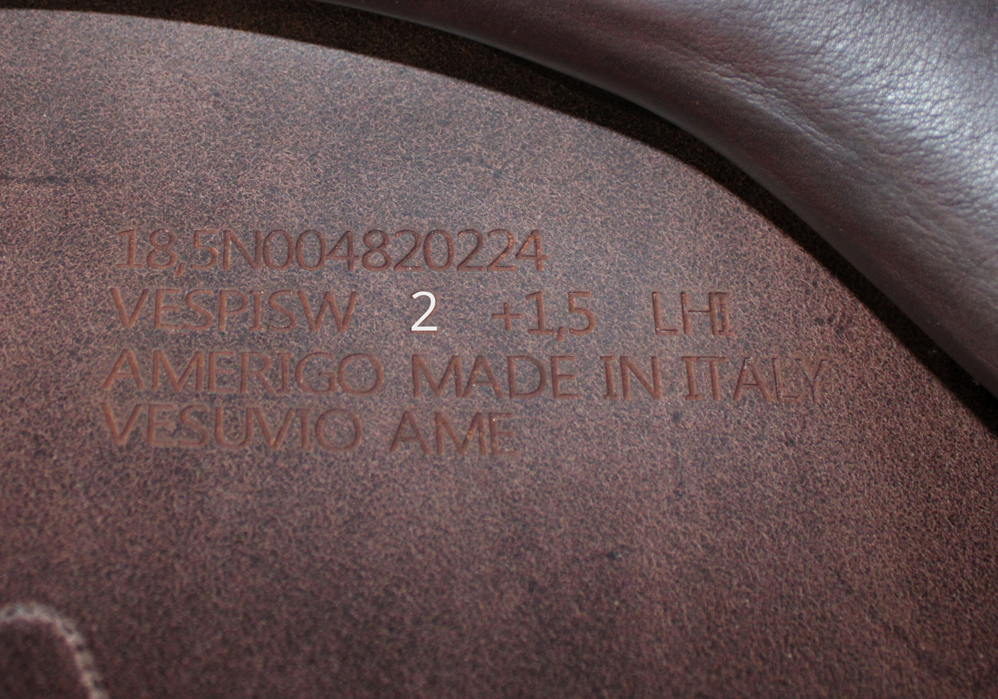 Close up of an Amerigo stamp with "2" highlighted in white text.