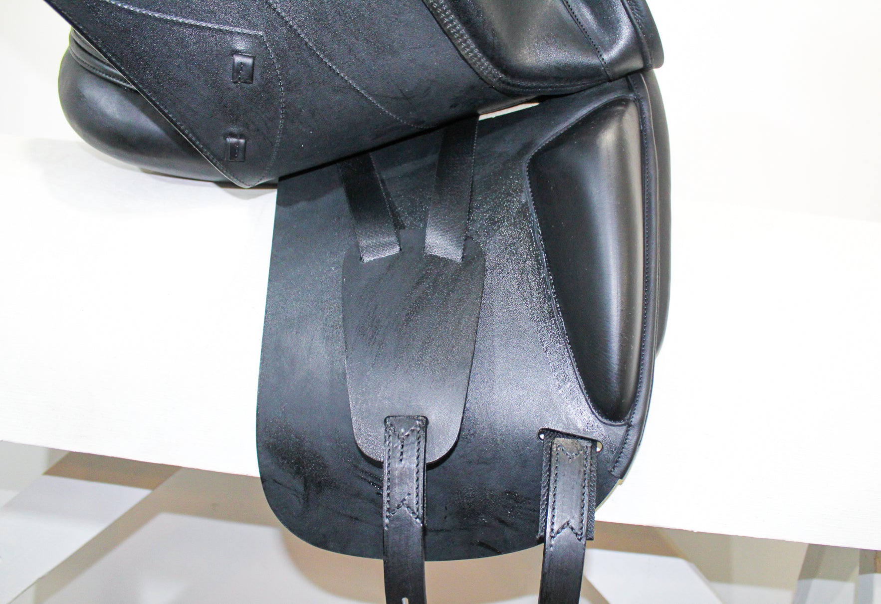 Right side profile view of an Amerigo Pasubio dressage saddle with the main flap lifted to see the billets and front blocks.