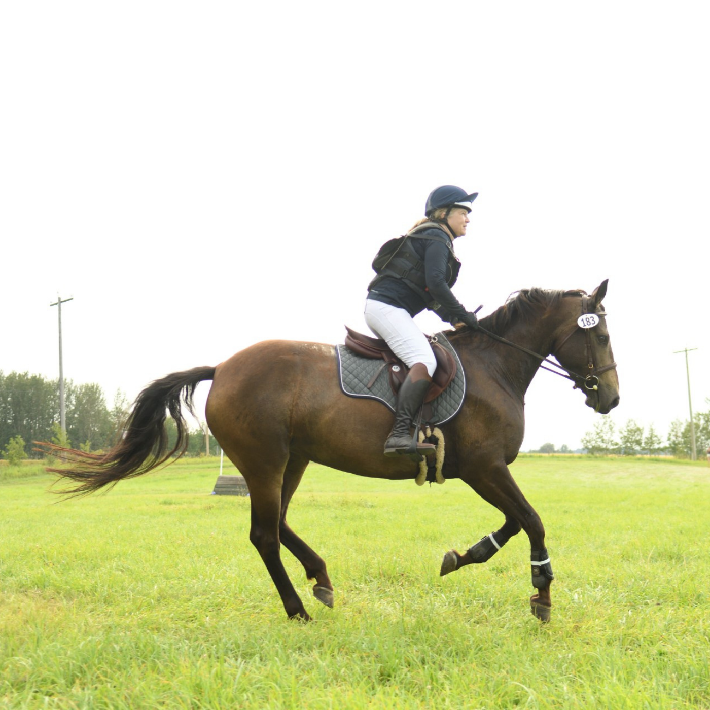 Kelli Long galloping her horse on the cross country field.