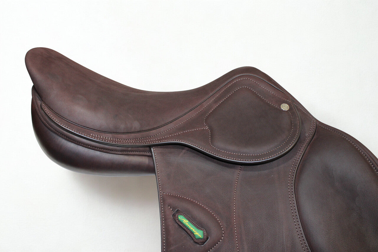 Close up right side profile view of an Amerigo DJ dual flap jump saddle in brown buffalo leather, with a green and yellow Amerigo logo loop.