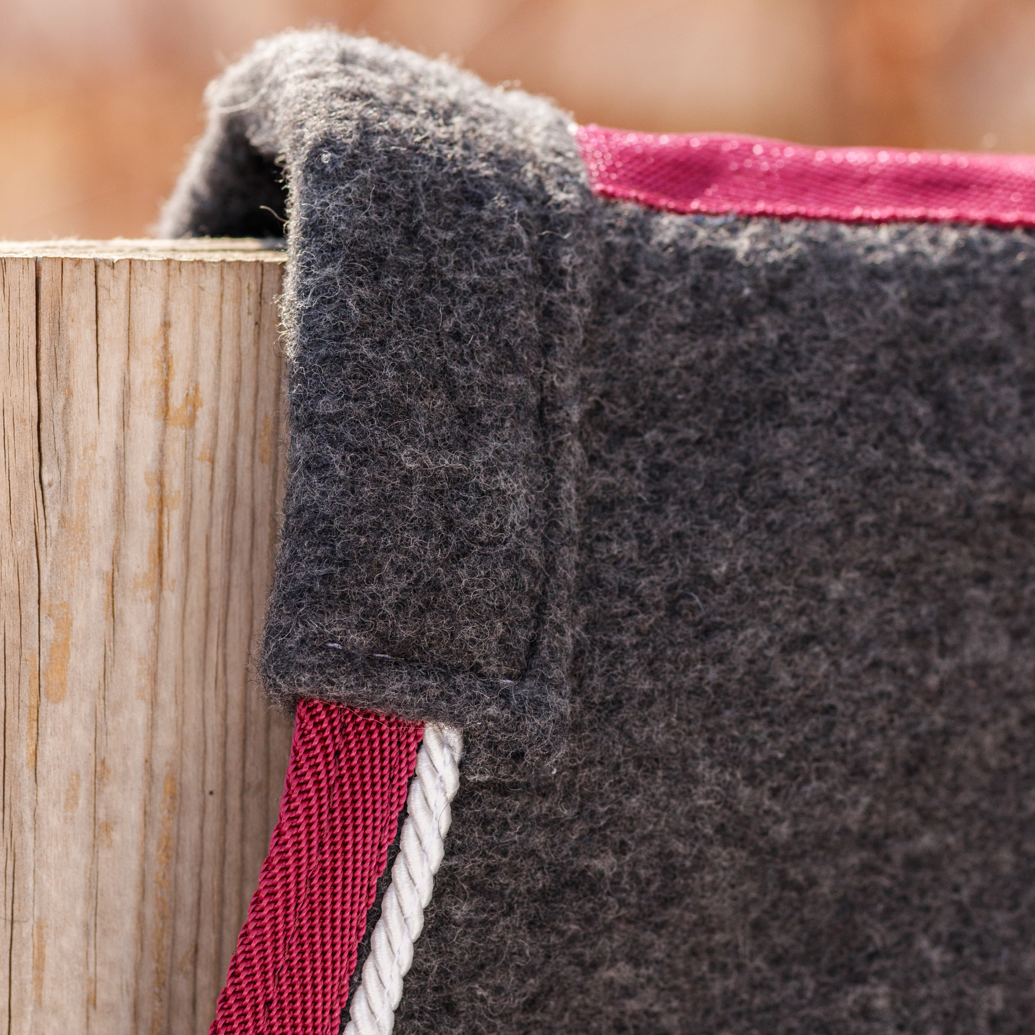 Close-up of a grey polyester show sheet with burgundy binding, grey cord, and padded wither.