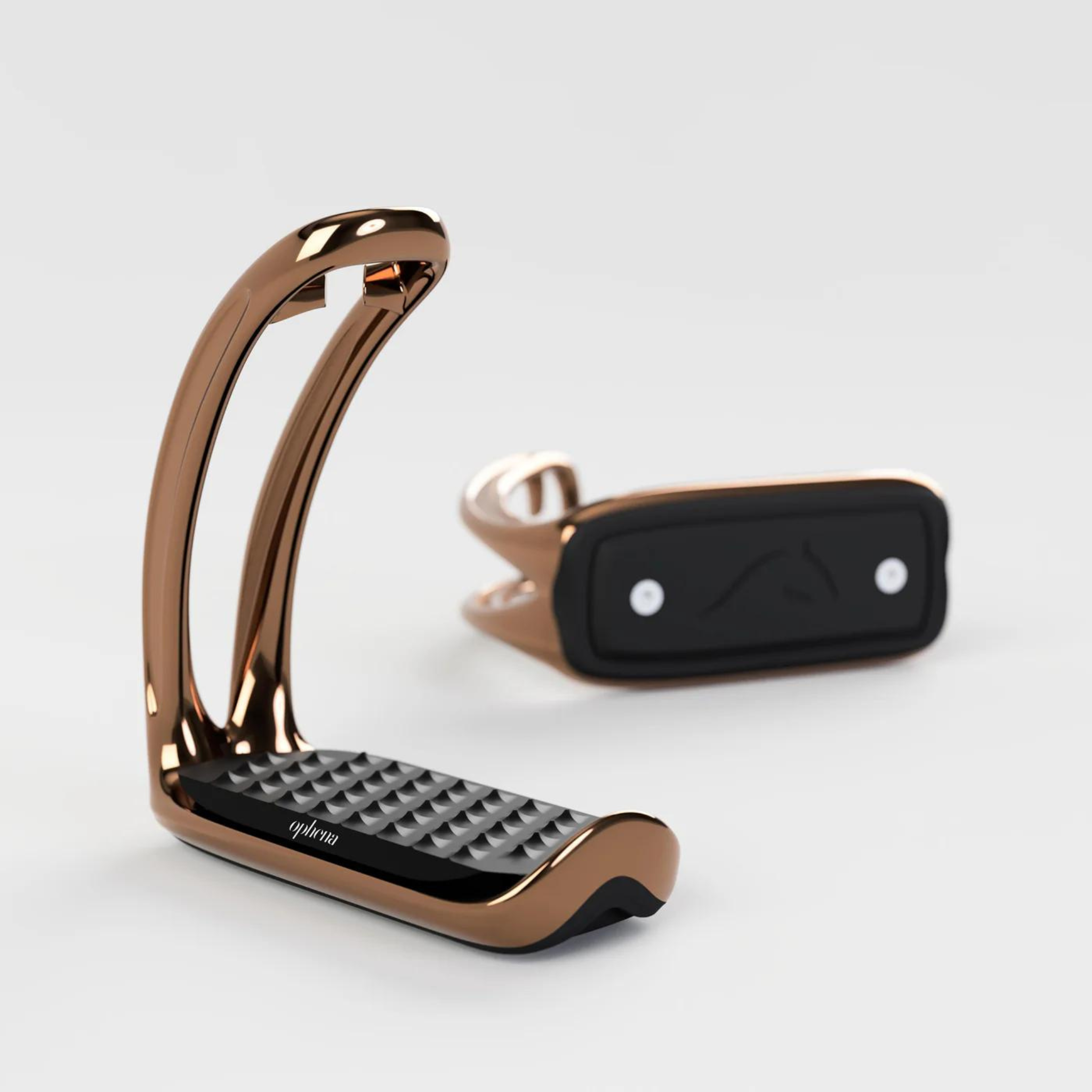 A pair of rose gold Ophena magnetic safety stirrups with a black pro-grip footbed and no outer branch, displayed against a white background.