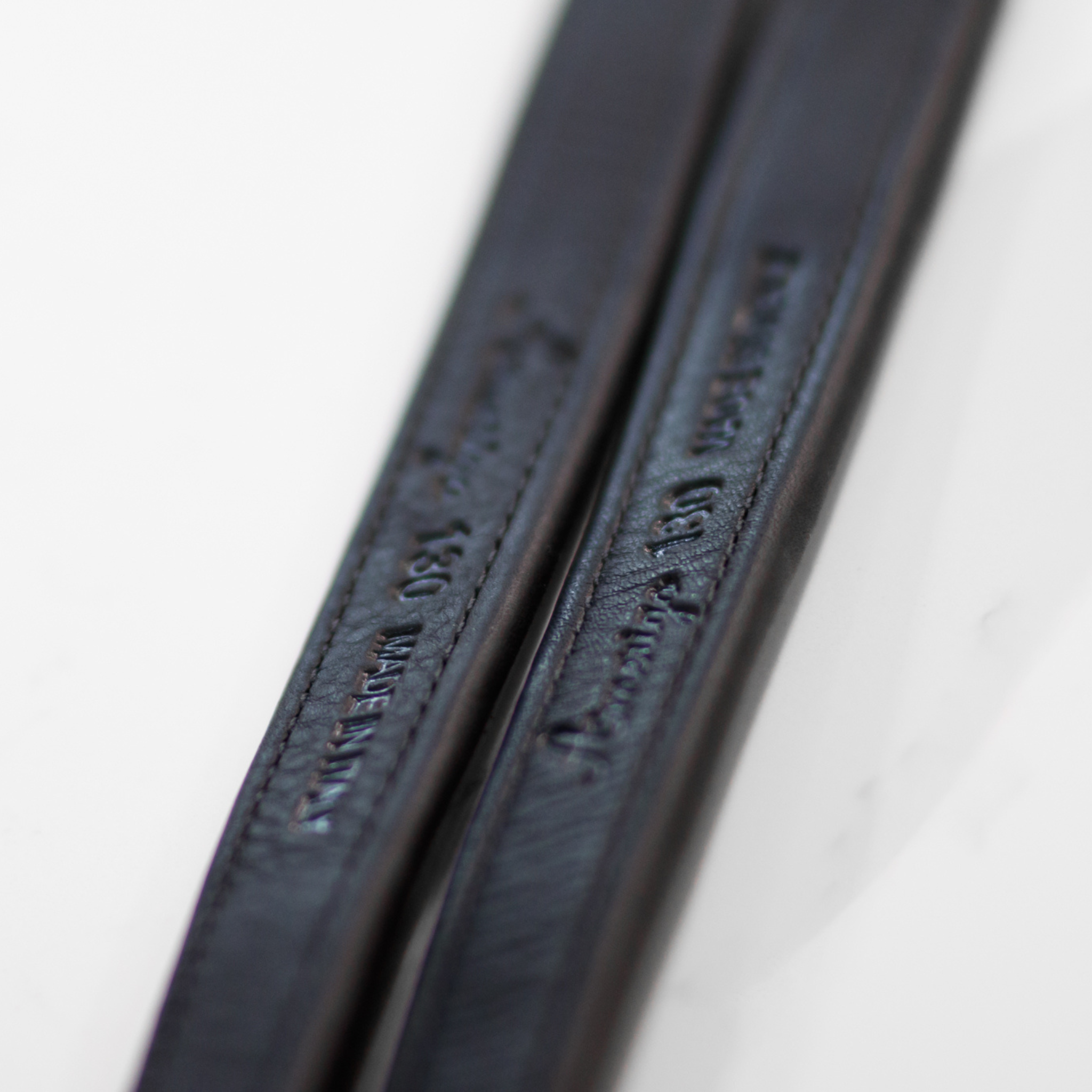 Close-up of black Amerigo mono stirrup leathers with stamped Amerigo logo on the mid-section