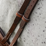 Close up photo of the hunter bridle cheekpieces on a grey horse. Photo focuses on the secondary keepers which are lined with rubber for extra grip.