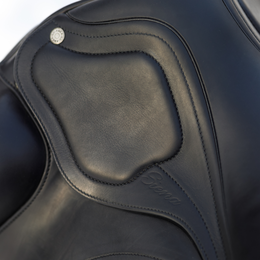 Close up photo showing the  padded skirt of a black Amerigo Classic dressage saddle. The saddle is stamped with 'Siena' on the skirt.
