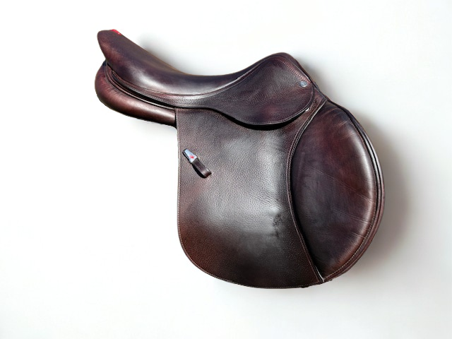 Right side profile view of an Equipe Performance dual flap jump saddle in brown grain calf leather, with a sliver emblem on the stirrup leather keeper.