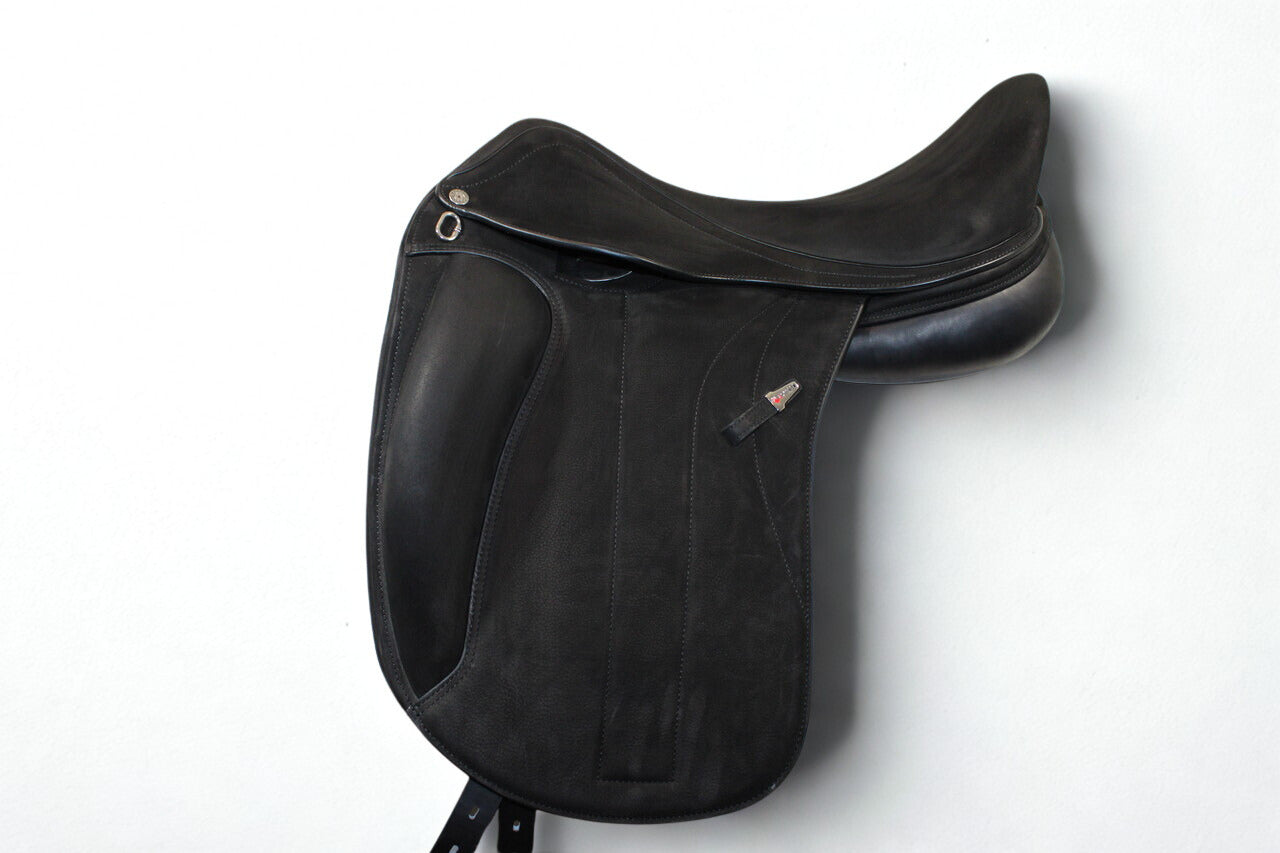Left side profile view of an Equipe Victoria dressage saddle in black buffalo leather, with a silver emblem on the stirrup leather keeper. 