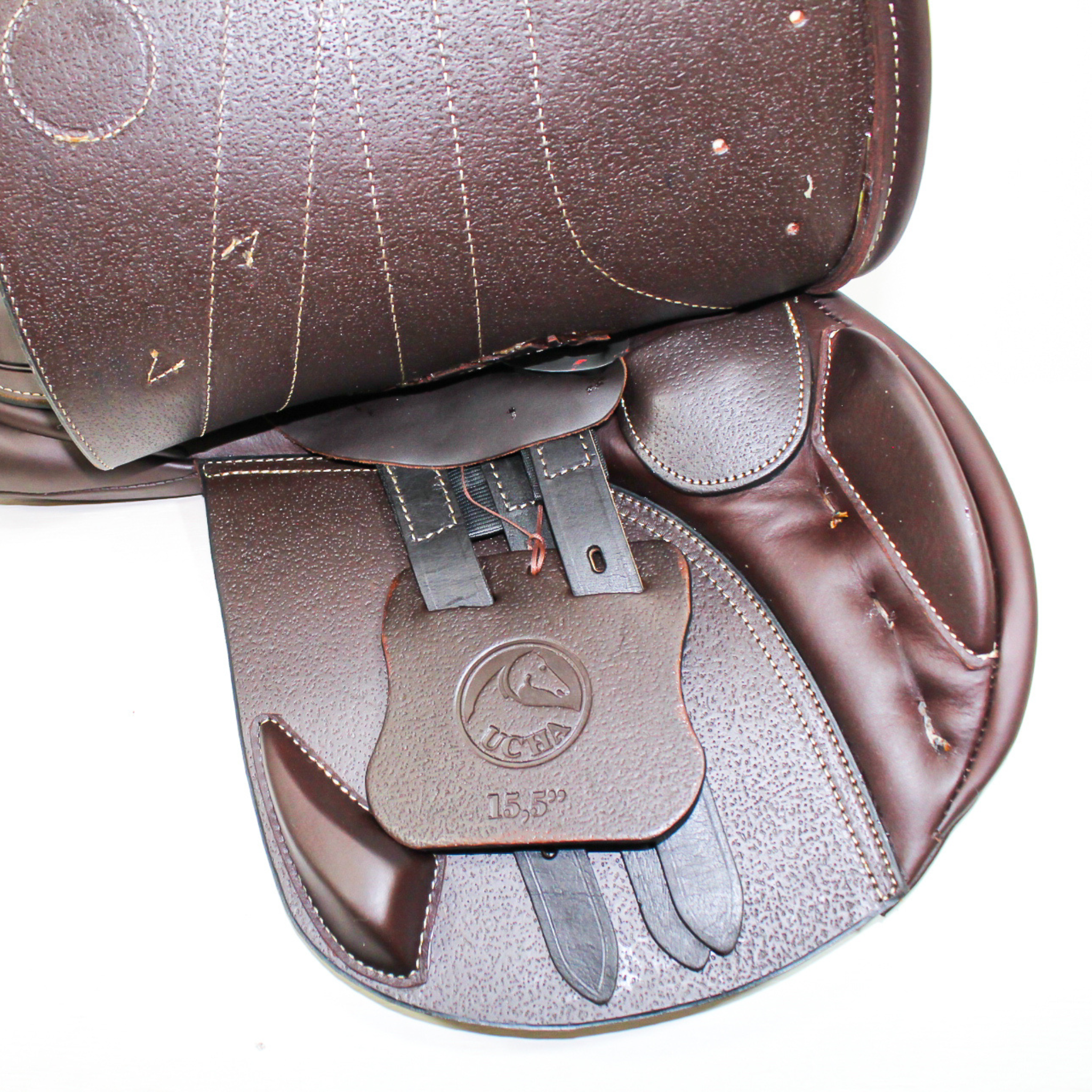 Right side profile view of an Ucha Joven dual flap jump saddle with the main flap lifted to see the billets, front blocks, and back blocks.