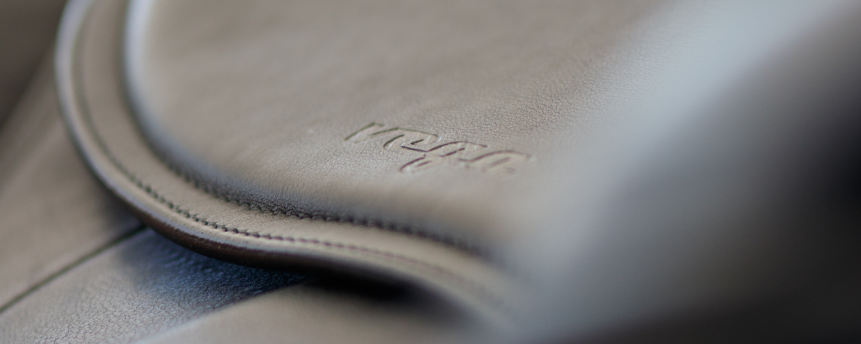 Close-up of an Amerigo Vega dressage saddle with "Vega" stamped on the leather. 