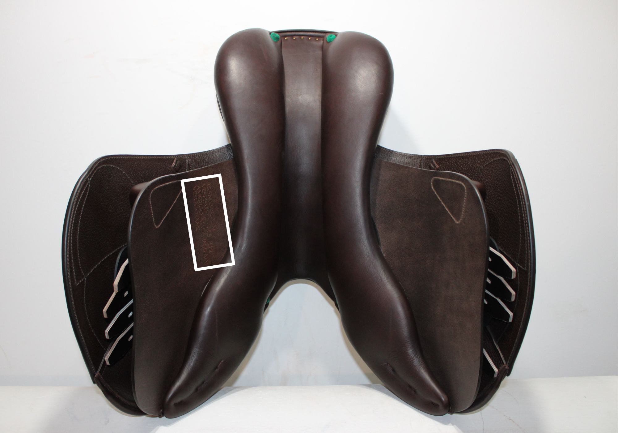 Underside view of an Amerigo jump saddle with a white box around the stamp highlighting its location.