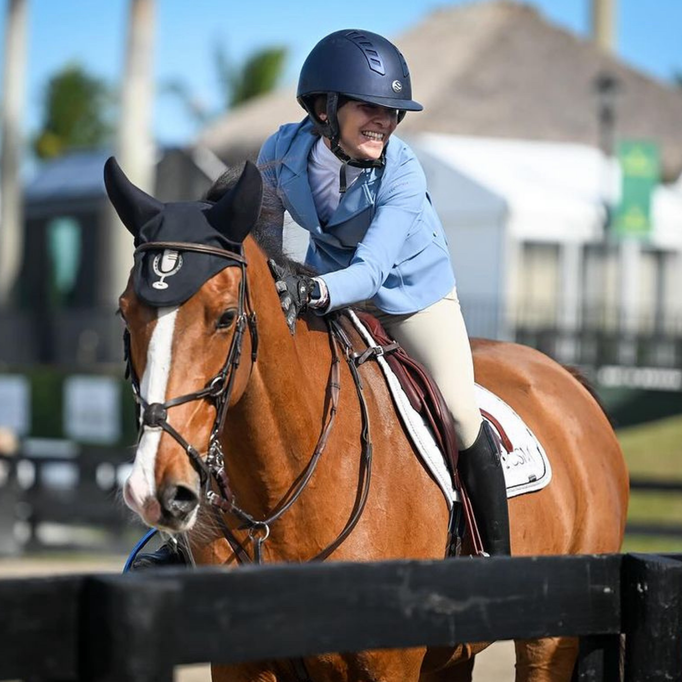Catie Staszak and Bear celebrating a great round with a smile and a pat while exiting the show ring.