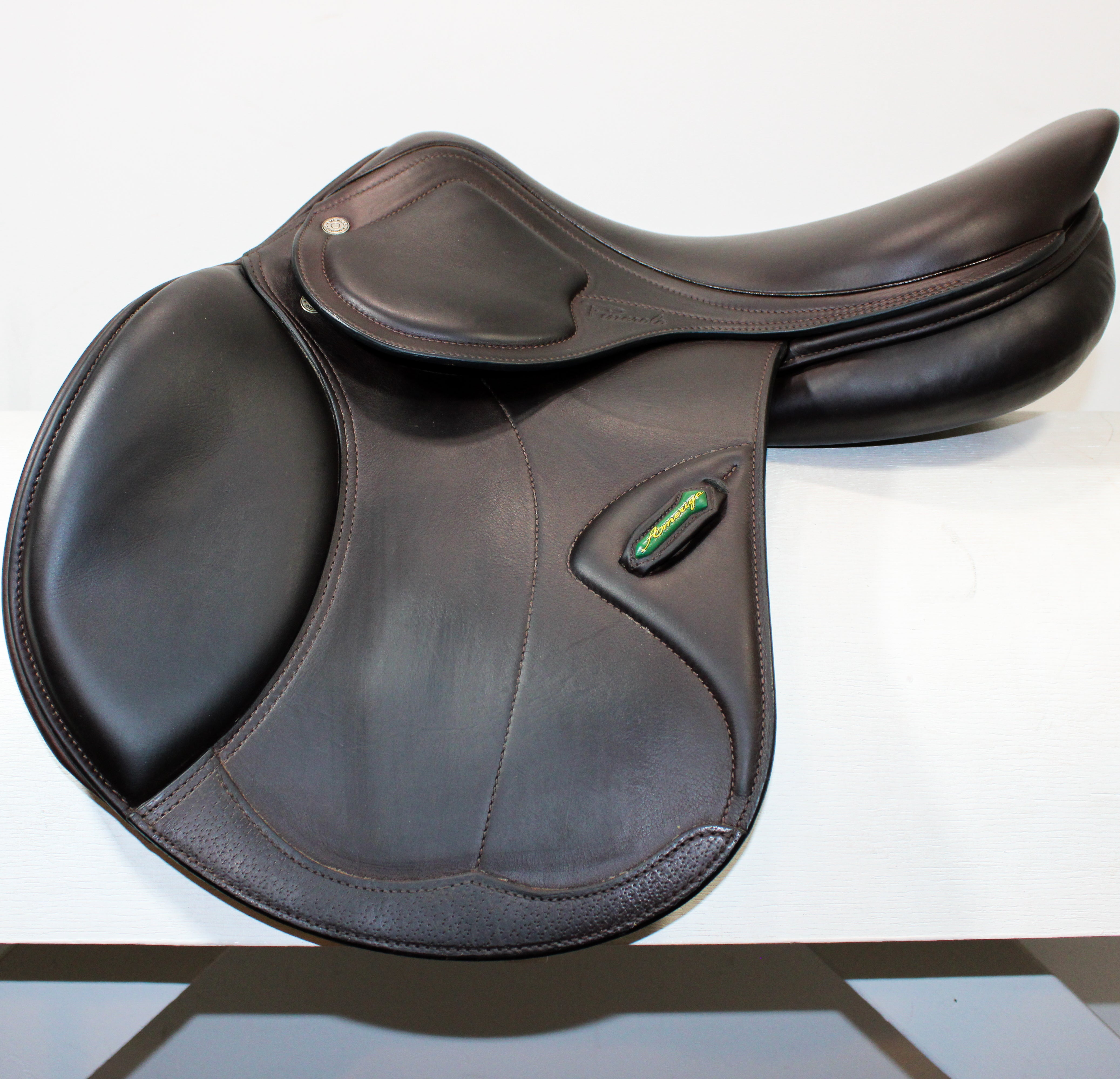 Left side profile view of an Amerigo DJ saddle in dark brown calf leather, with a green and yellow Amerigo logo loop