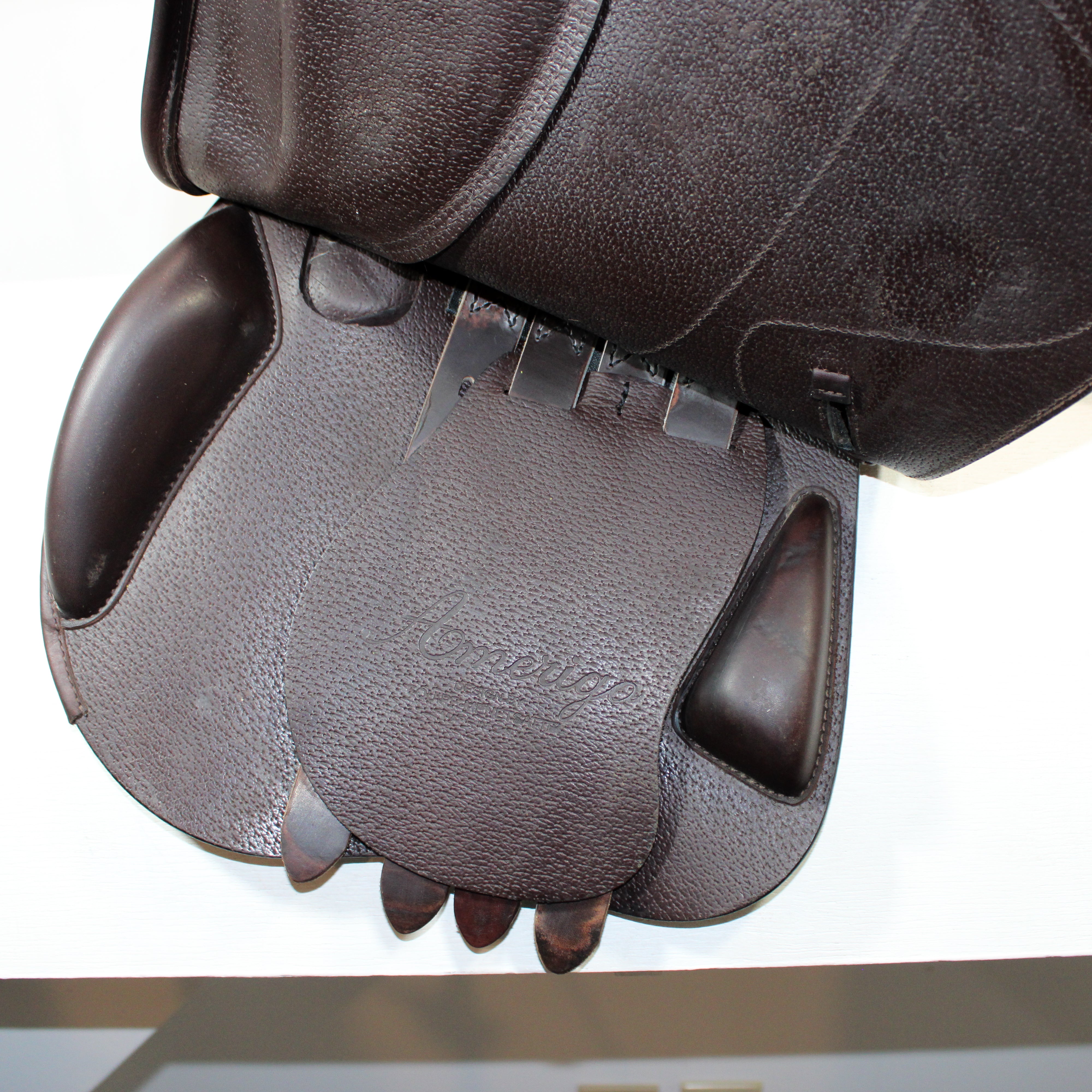 Left side profile view of an Amerigo DJ dual flap jump saddle with the main flap lifted to see the billets, front blocks, and back blocks. 