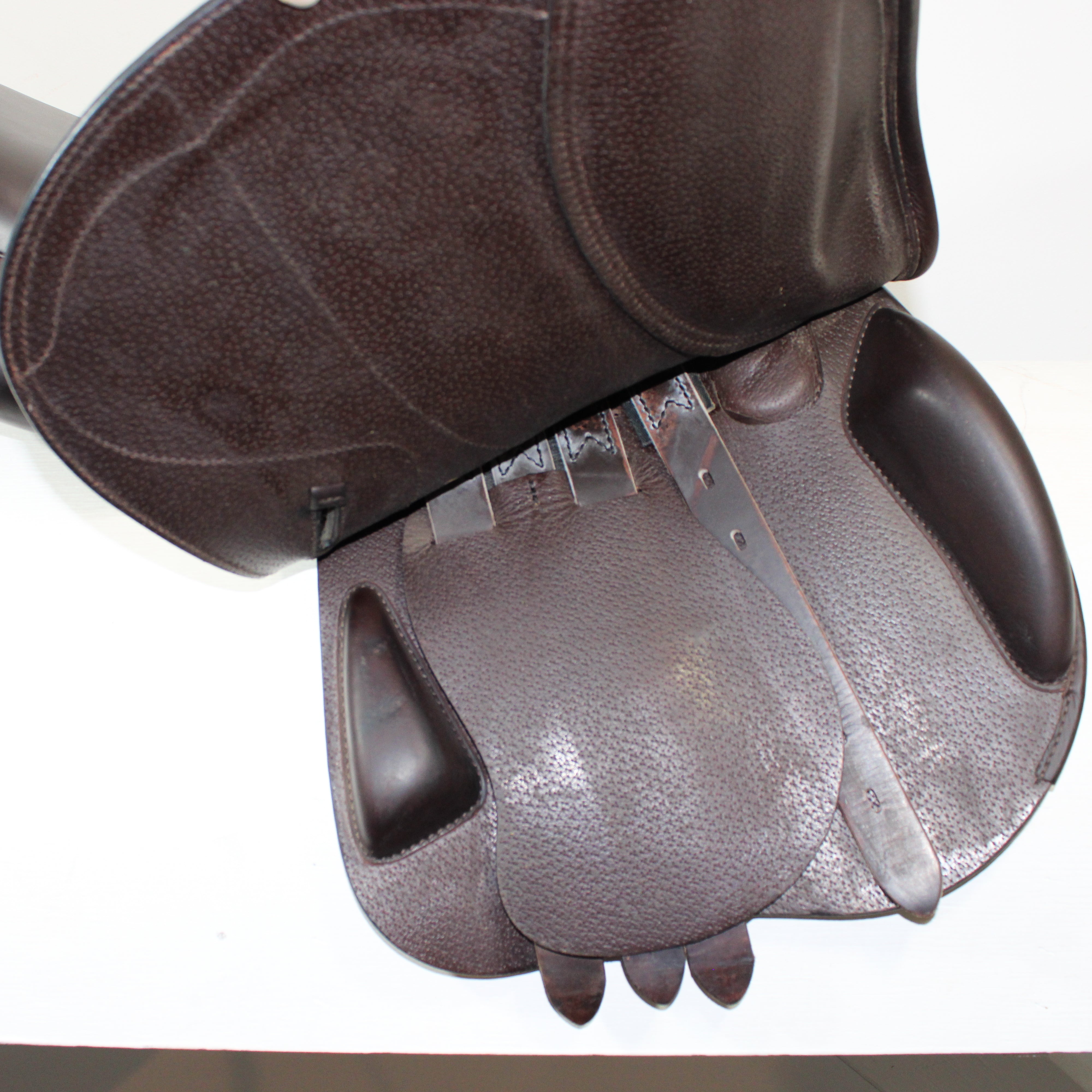 Right side profile view of an Amerigo DJ dual flap jump saddle with the main flap lifted to see the billets, front blocks, and back blocks. 