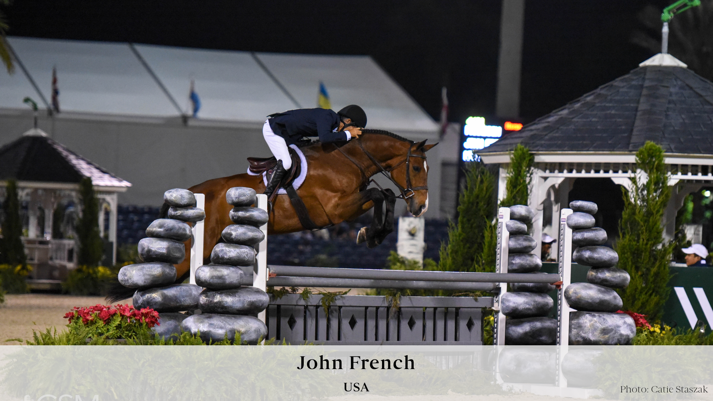 USA hunter rider John French and Paradigm jumping over a grey hunter fence with stacked stone standards