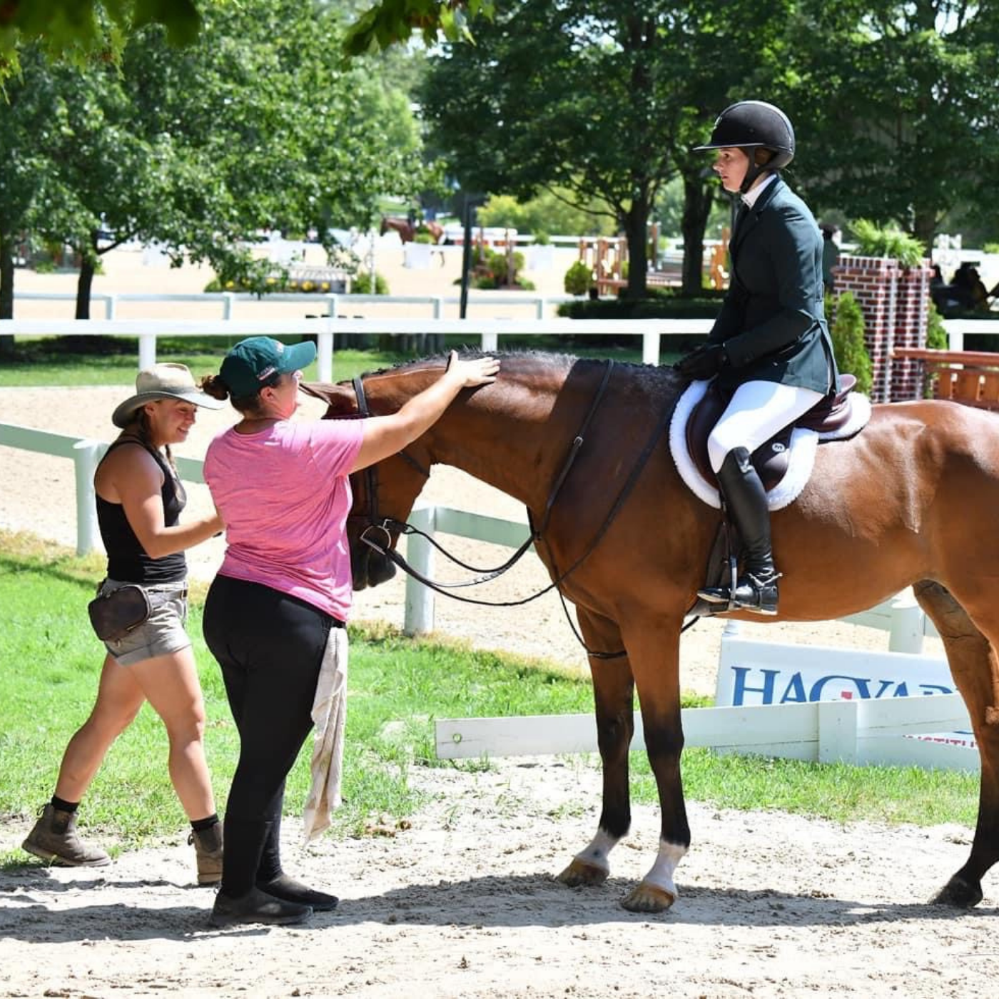 Kimmy Risser petting her horse at the in gate. 