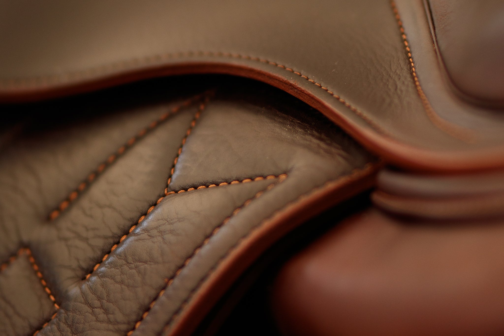 Close up of "M" stitching on brown Meyer saddle