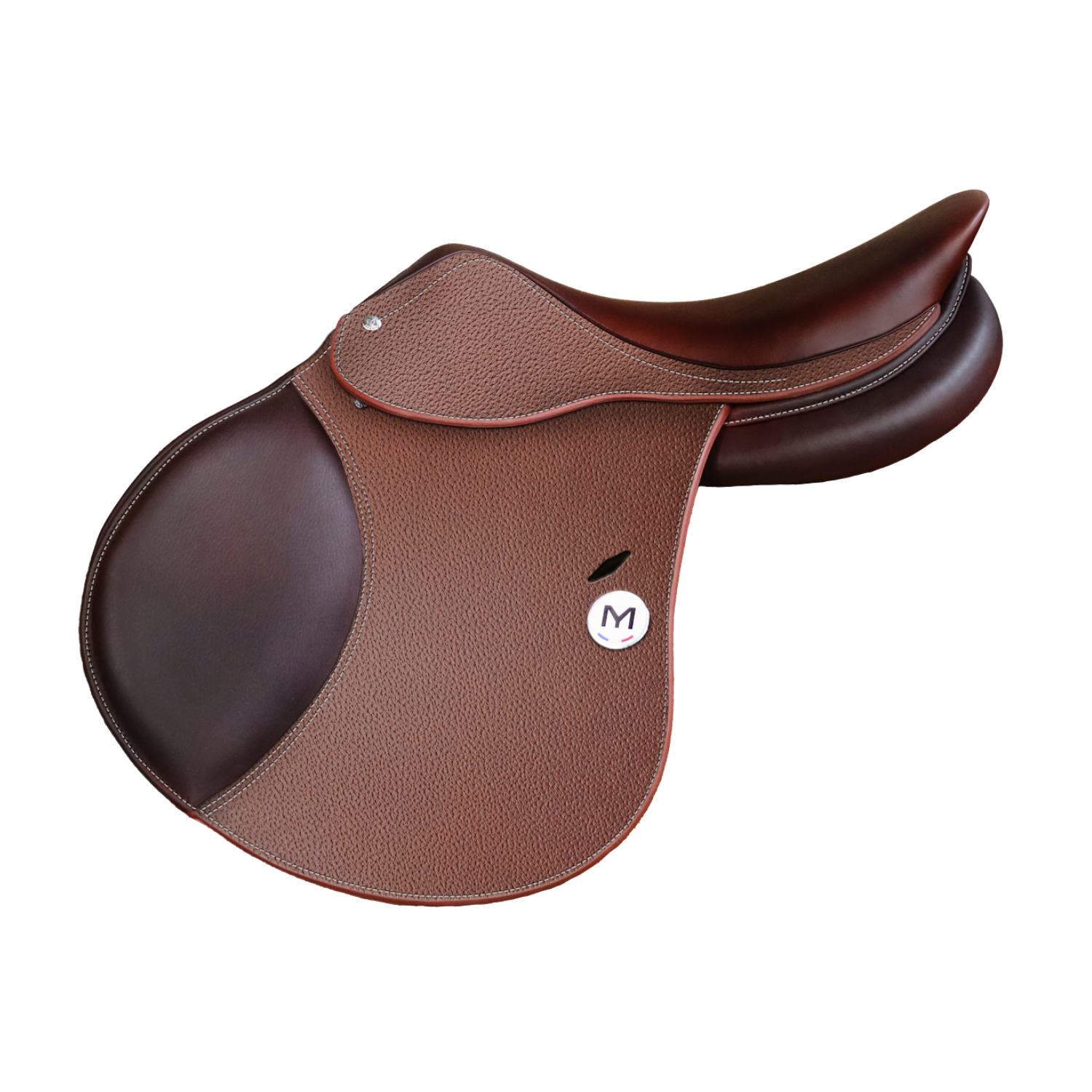 Side view of a brown grain leather Meyer Act 1 jump saddle with a circular white badge featuring a black letter 'M' and a small French tricolor detail.