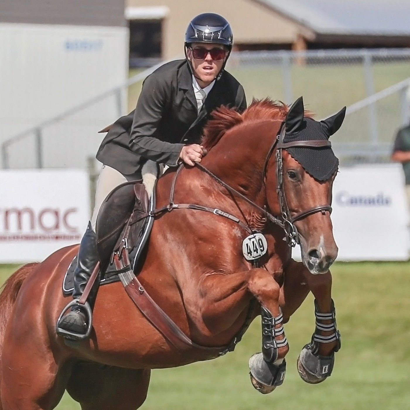 Ty Kueber and Leader La Loi KF jumping at an equestrian competition.