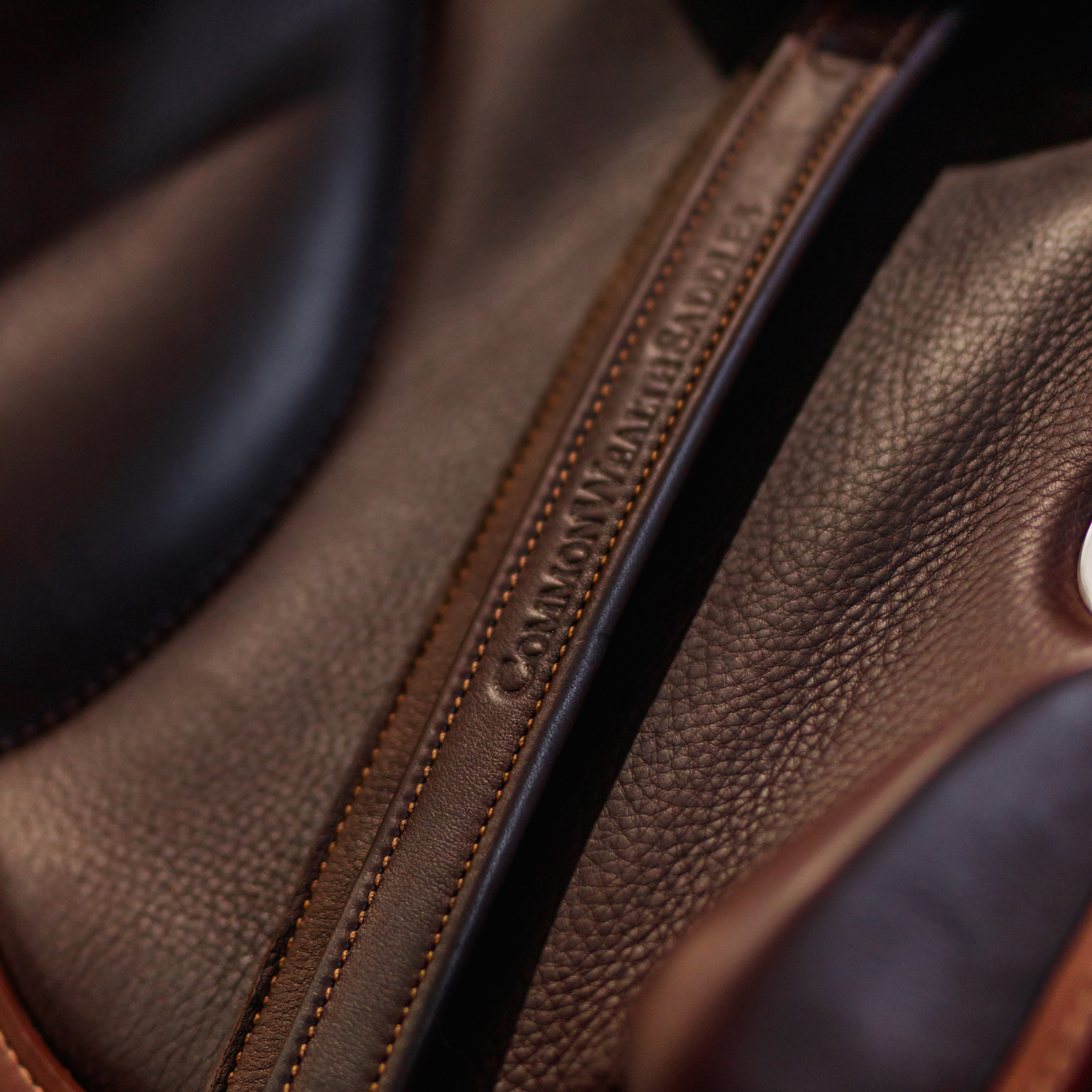 Brown Yoho rolled stirrup leathers hanging from a brown monoflap saddle.