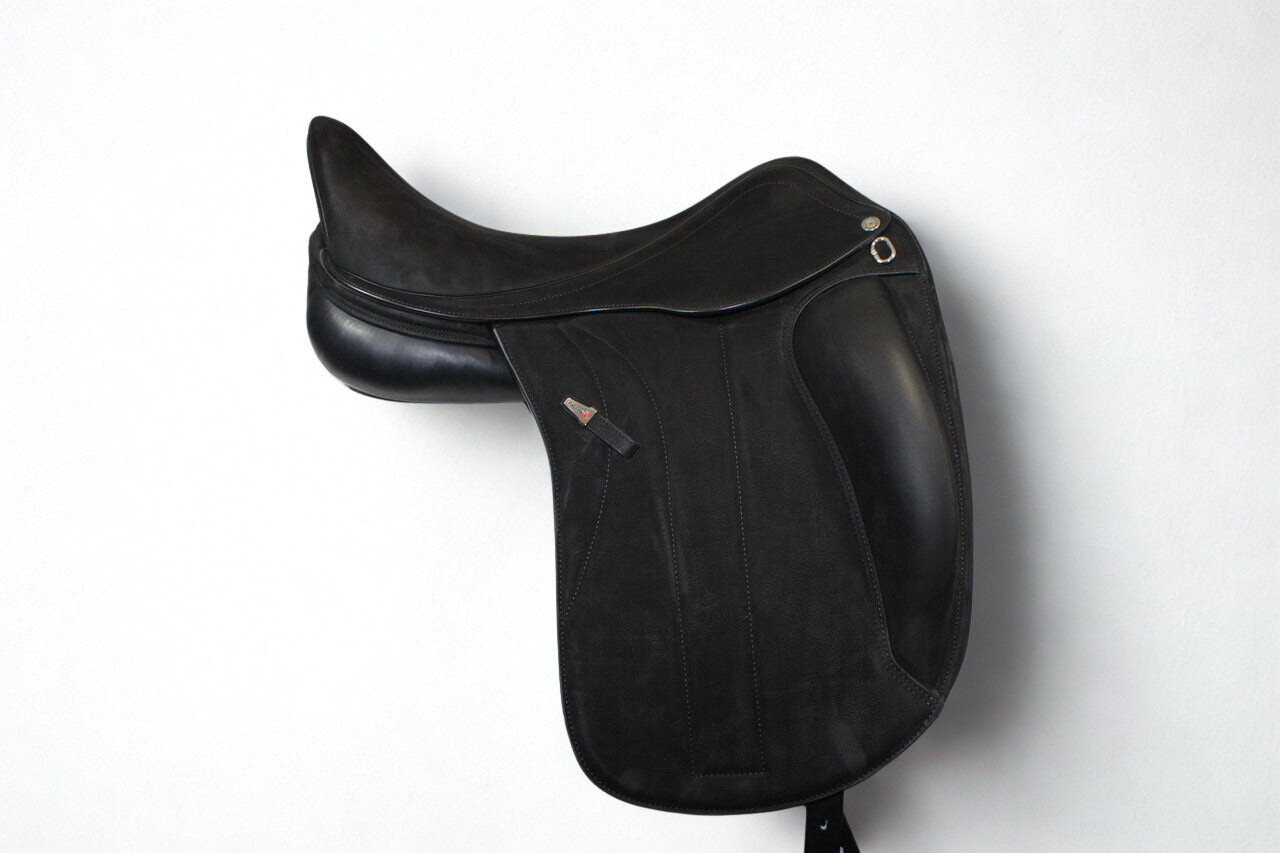 Right side profile view of an Equipe Victoria dressage saddle in black buffalo leather, with a silver emblem on the stirrup leather keeper. 
